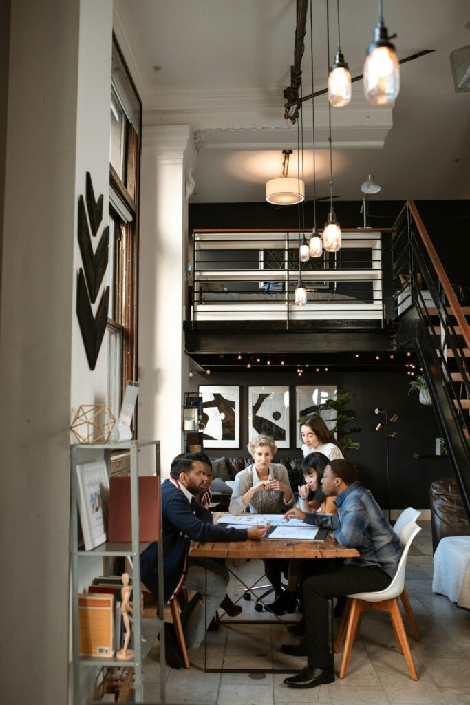 A diverse group of professionals collaborate in a stylish, modern coworking space with loft design.
